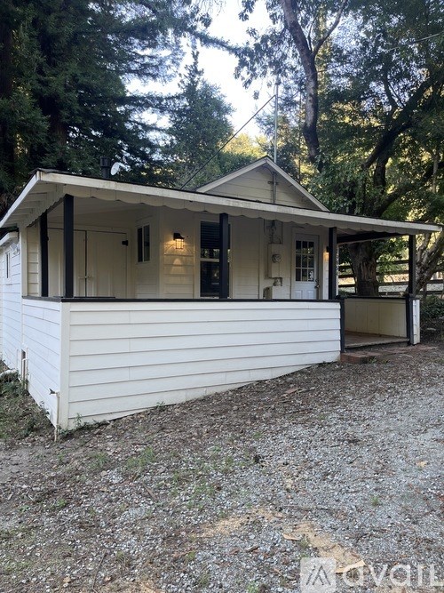 A white house with a porch and a covered entrance.