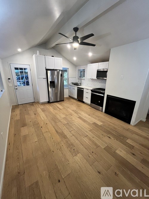 A kitchen with wooden floors and white walls.