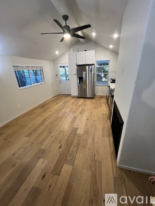 A room with wooden flooring and a ceiling fan.