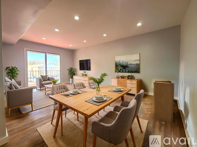 A well-lit dining room with a wooden table and chairs.