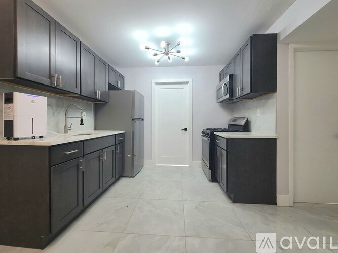 A kitchen with dark brown cabinets and a white door.