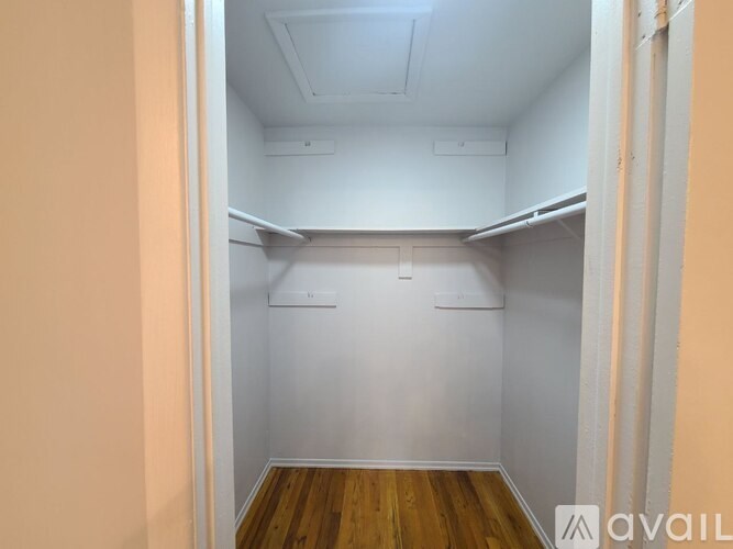 A small, empty room with wooden floors and white walls.