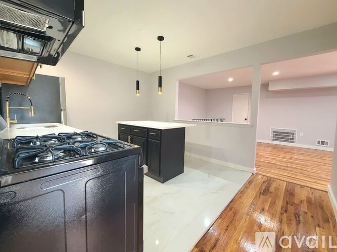 A kitchen with a black stove top oven and a black cabinet.