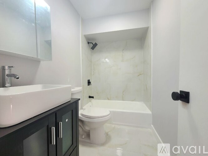 A bathroom with a white sink and toilet.