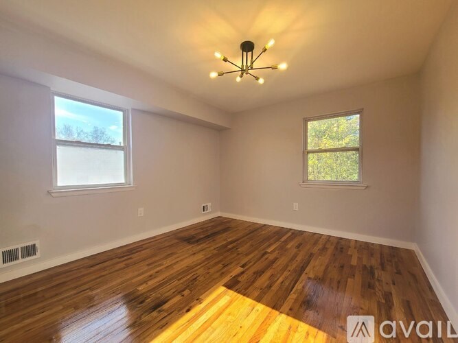 A room with wooden floors and a chandelier.
