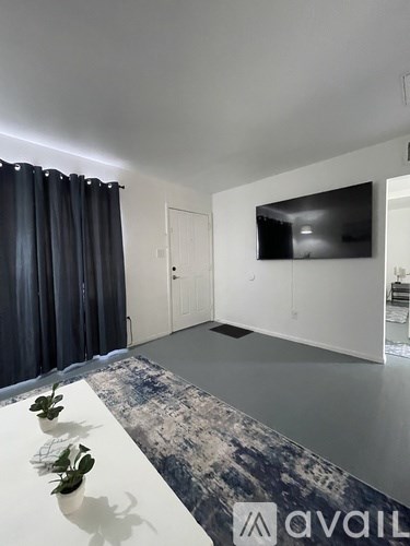 A modern living room with a flat screen TV mounted on the wall.