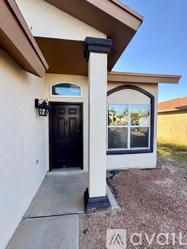 A house with a black door and a window is shown.