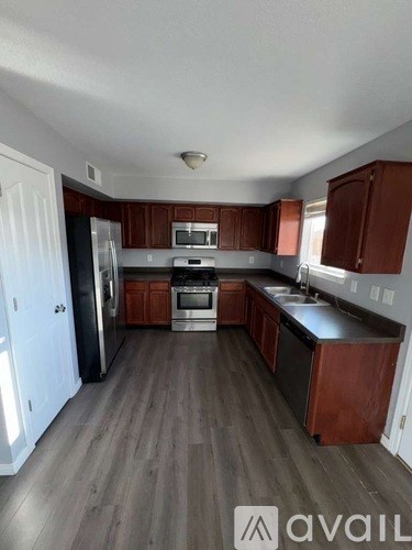 A kitchen with wooden cabinets and a refrigerator.