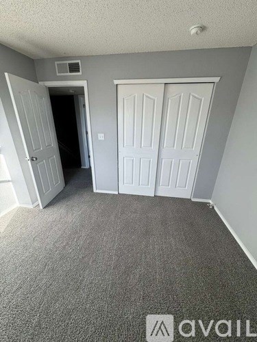 A room with two doors and a carpeted floor.