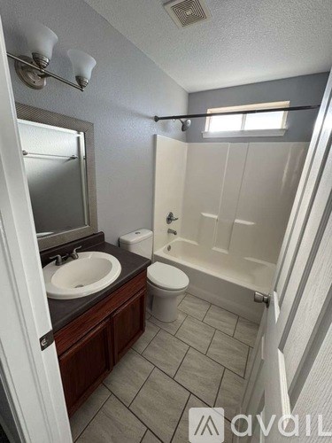 A bathroom with a sink, toilet, and bathtub.