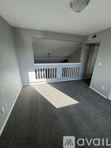 A room with a grey carpet and a white ceiling.