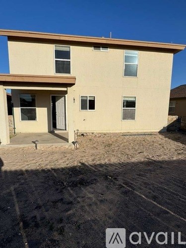 A beige house with a brown roof and a white door.