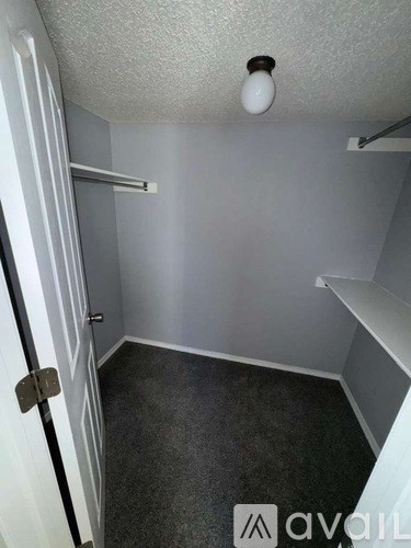 A small, empty room with a door on the left and a light on the ceiling.