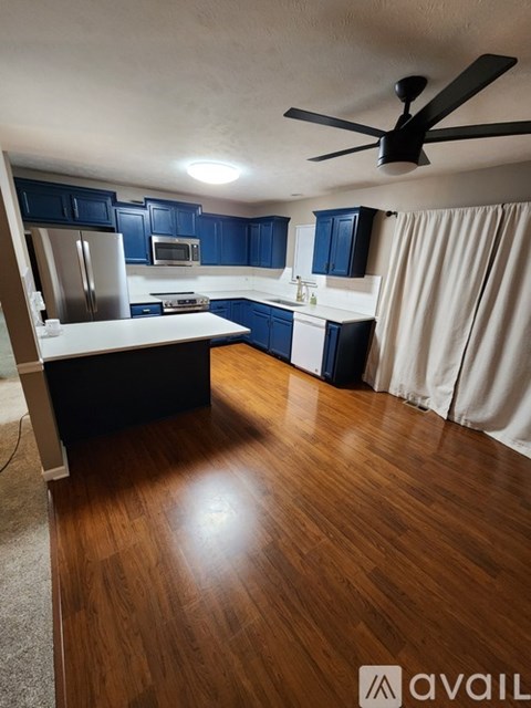 A kitchen with dark blue cabinets and a white countertop.