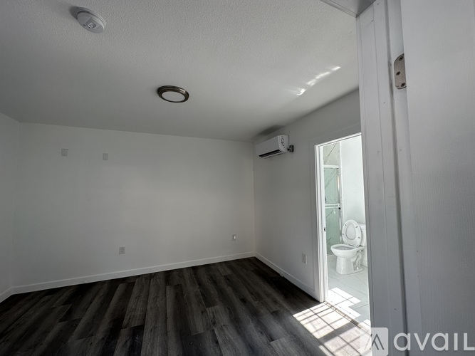 A room with wooden flooring and a sliding glass door.