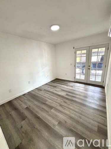 A room with wooden flooring and a sliding glass door.
