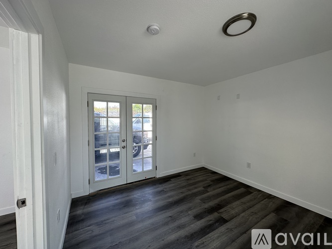 A white door is on the right side of a hallway with a window on the left.