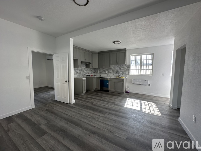 A room with wooden flooring and a wall-mounted air conditioner.