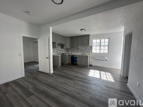 A room with wooden flooring and a wall-mounted air conditioner.