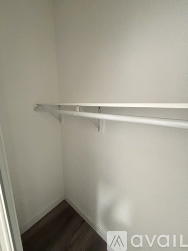 A white wall with a shelf and a white door.