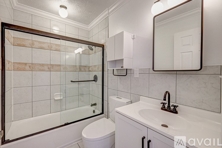 A bathroom with a toilet, sink, and mirror.