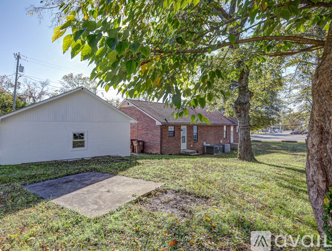 A white house with a red brick house in the background.