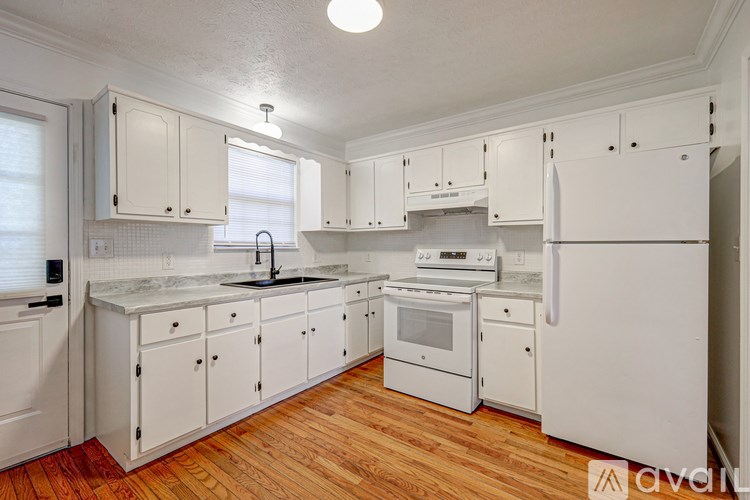 A kitchen with white appliances and cabinets.