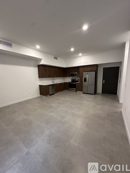 A spacious room with a kitchenette and a refrigerator.