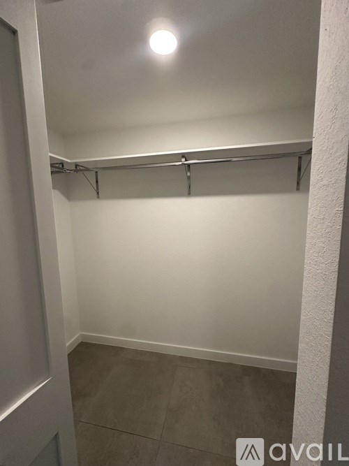 A white closet with a shelf and a light on.