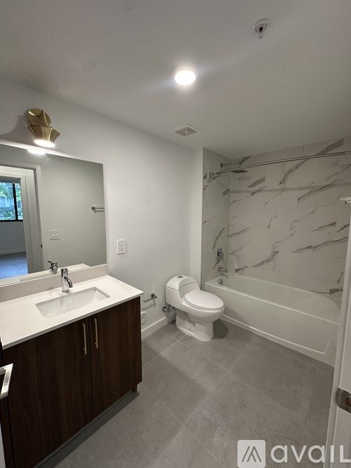 A bathroom with a marble wall and a toilet.