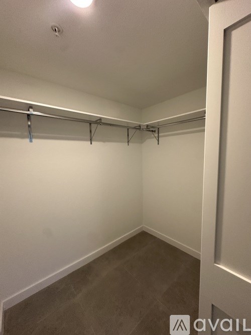 A room with a white wall and a grey floor.