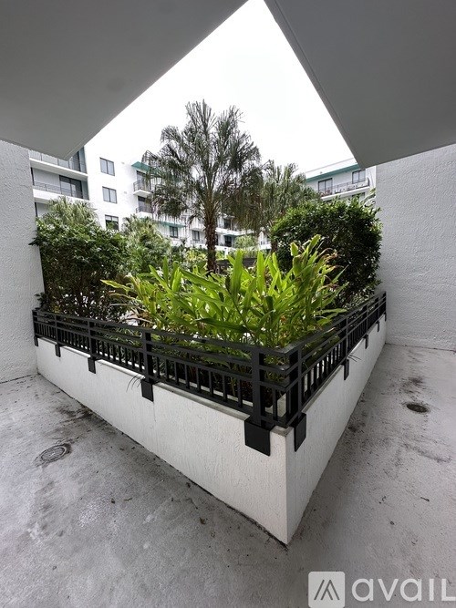 A balcony with a black railing and green plants.