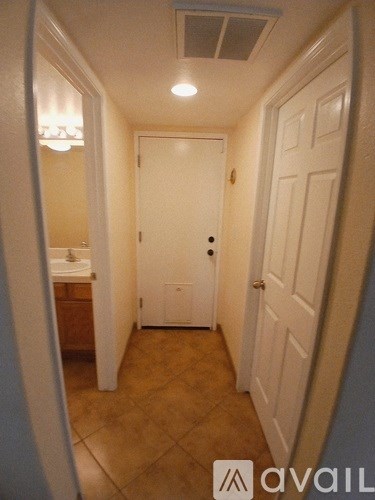 A hallway with a white door and a white sink.