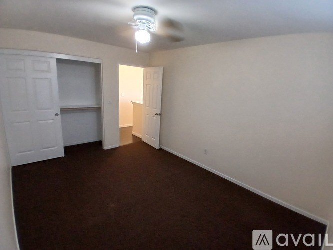 A room with a carpeted floor and a white door.