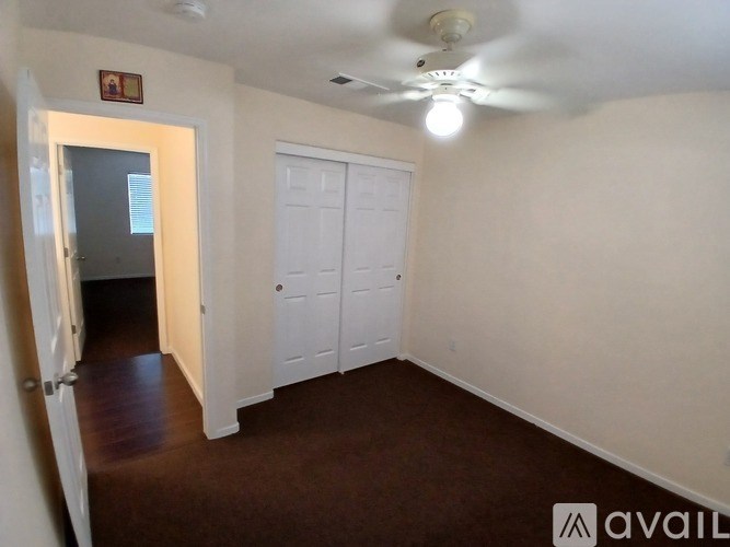 A room with a ceiling fan and two doors.