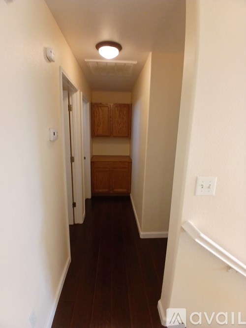 A hallway with wood floors and white walls.