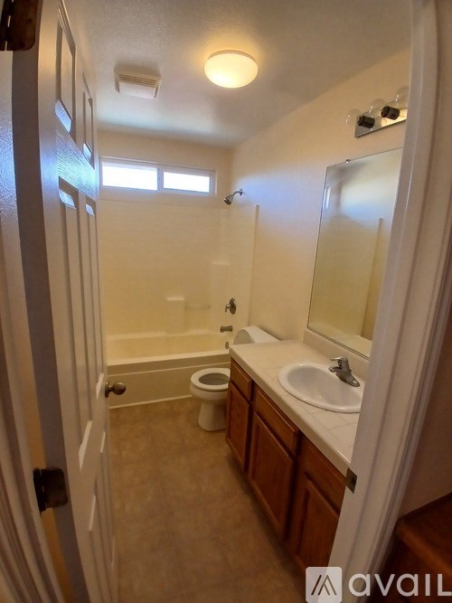A bathroom with a toilet, sink, and mirror.