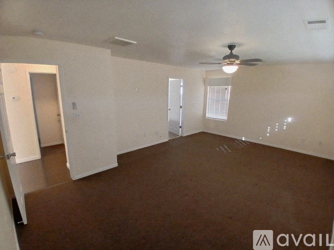 Empty room with brown floor and white walls.