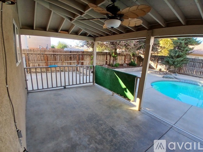 A patio with a pool and a fan.