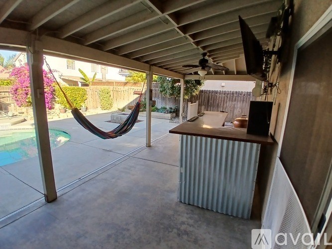 A hammock is hanging in a covered patio area.