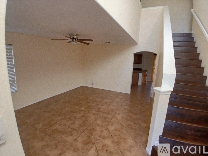 A room with a staircase and a ceiling fan.