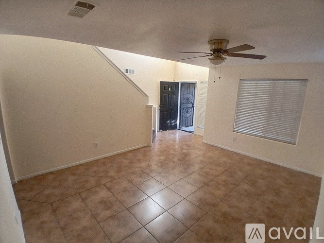 A spacious room with a ceiling fan and tiled flooring.