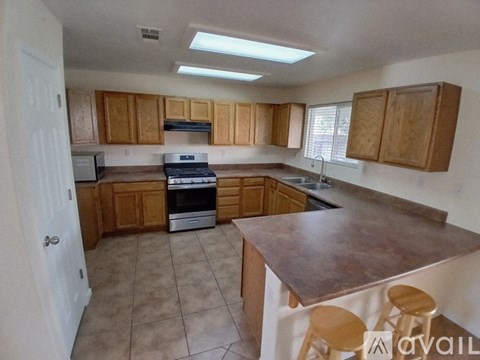 A kitchen with wooden cabinets and a brown countertop.