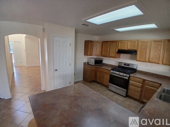 A kitchen with wooden cabinets and a stove top oven.