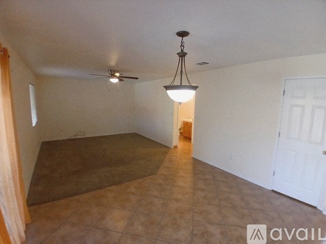 A room with a ceiling fan and a light hanging from the ceiling.