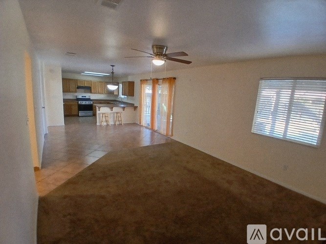 A living room with a ceiling fan and sliding glass doors.