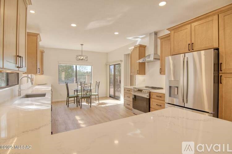A kitchen with wooden cabinets and a marble countertop.