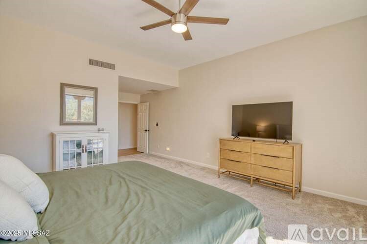 A bedroom with a bed, dresser, and window.