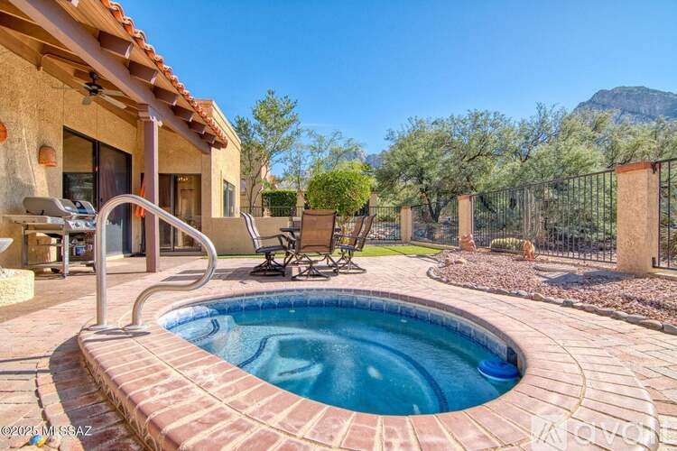A small pool in a backyard with a patio and chairs.