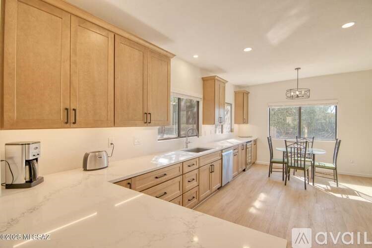 A kitchen with wooden cabinets and a marble countertop.